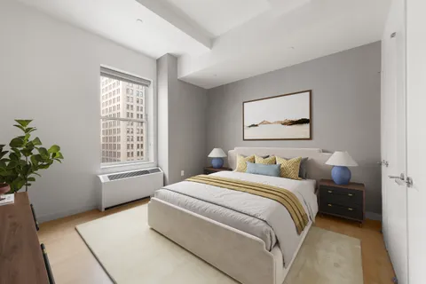 a bedroom with a bed potted plant and a window