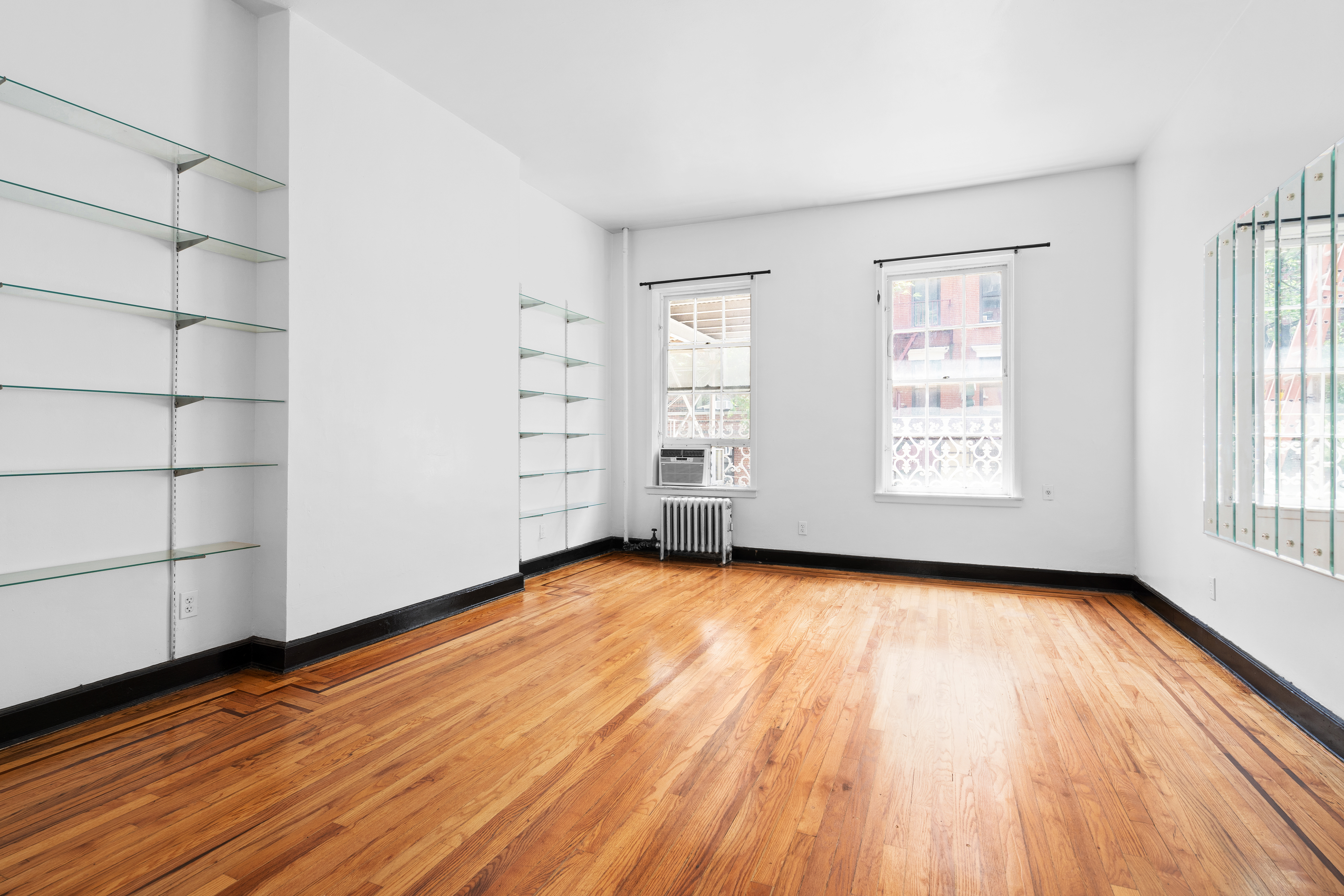 305 East 12th Street, Unit PARLOR Manhattan, NY 10003 - Photo 2 of 5 wooden floor in an empty room with a window