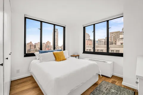 a bedroom with a bed and a large window