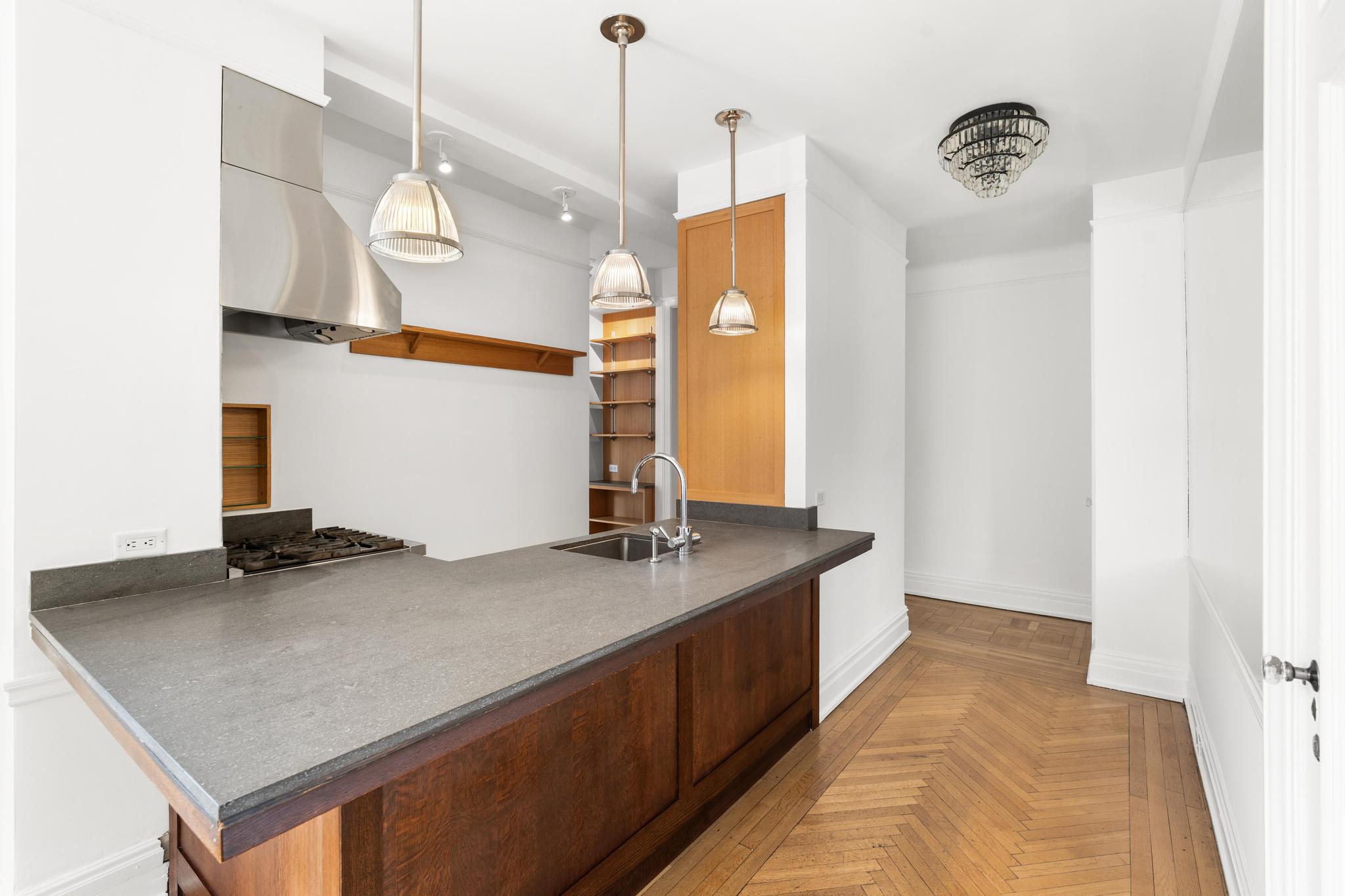 885 West End Avenue, Unit 12D Manhattan, NY 10025 - Photo 8 of 24 a kitchen with stainless steel appliances granite countertop a sink a counter space and a window