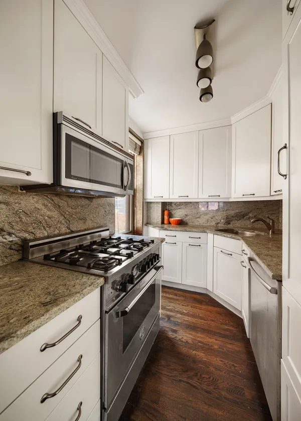 a kitchen with granite countertop cabinets stainless steel appliances and a wooden floor