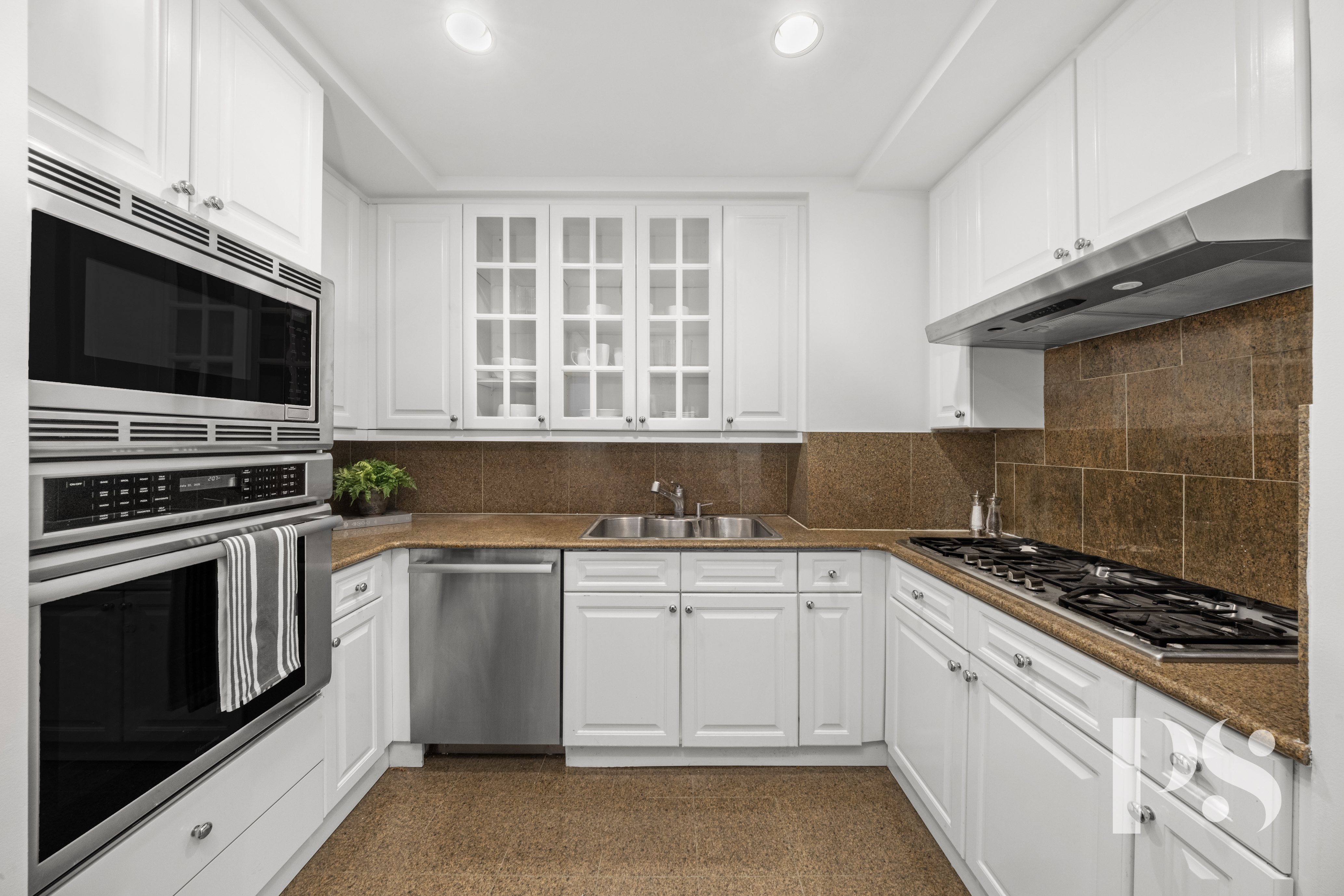 610 Park Avenue, Unit 4B Manhattan, NY 10065 - Photo 11 of 22 a kitchen with cabinets stainless steel appliances and a sink