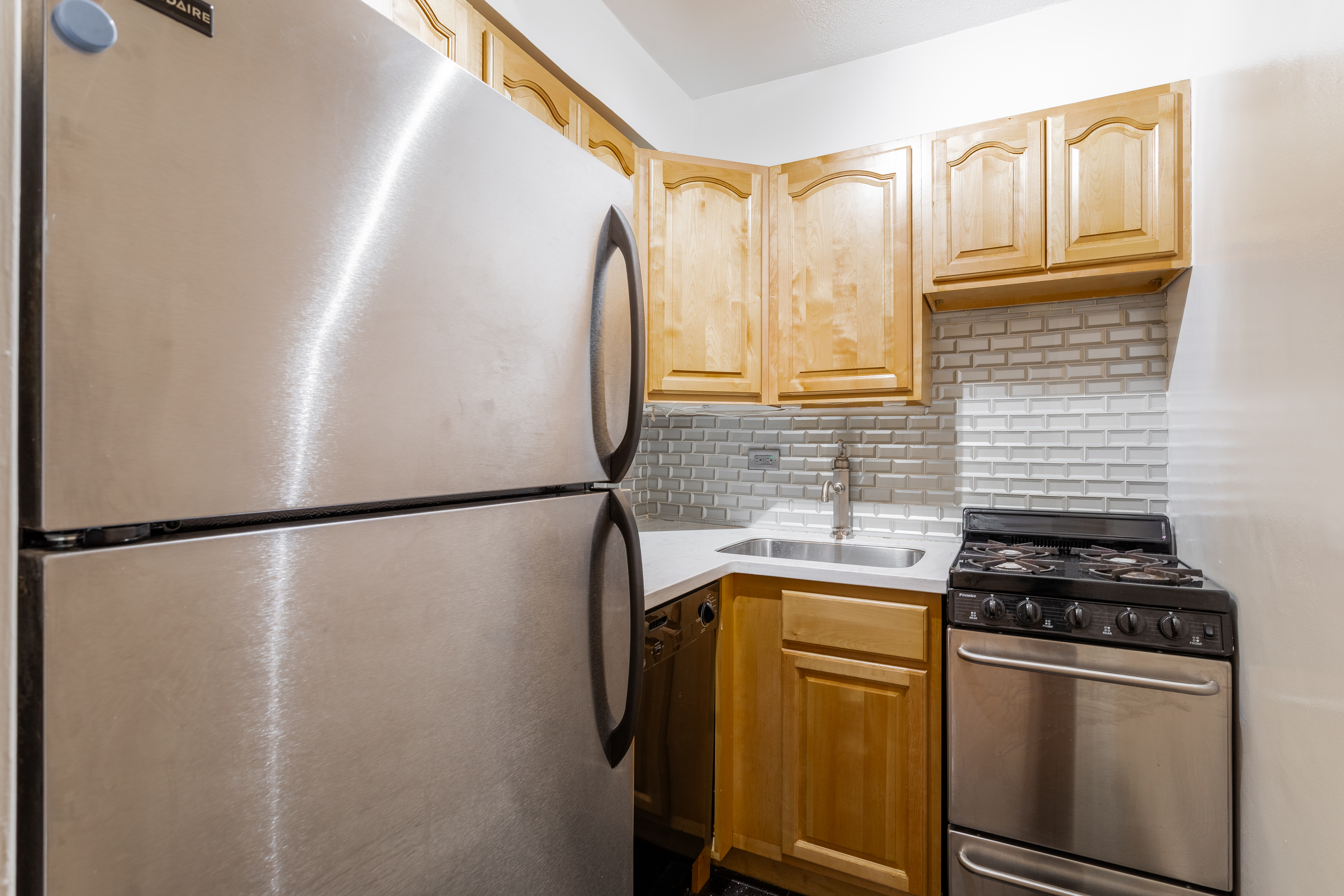 520 East 81st Street, Unit 1F Manhattan, NY 10028 - Photo 6 of 8 a white refrigerator freezer and a stove sitting inside of a kitchen