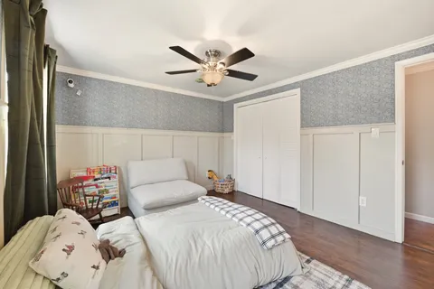 a bedroom with a bed couch and a window