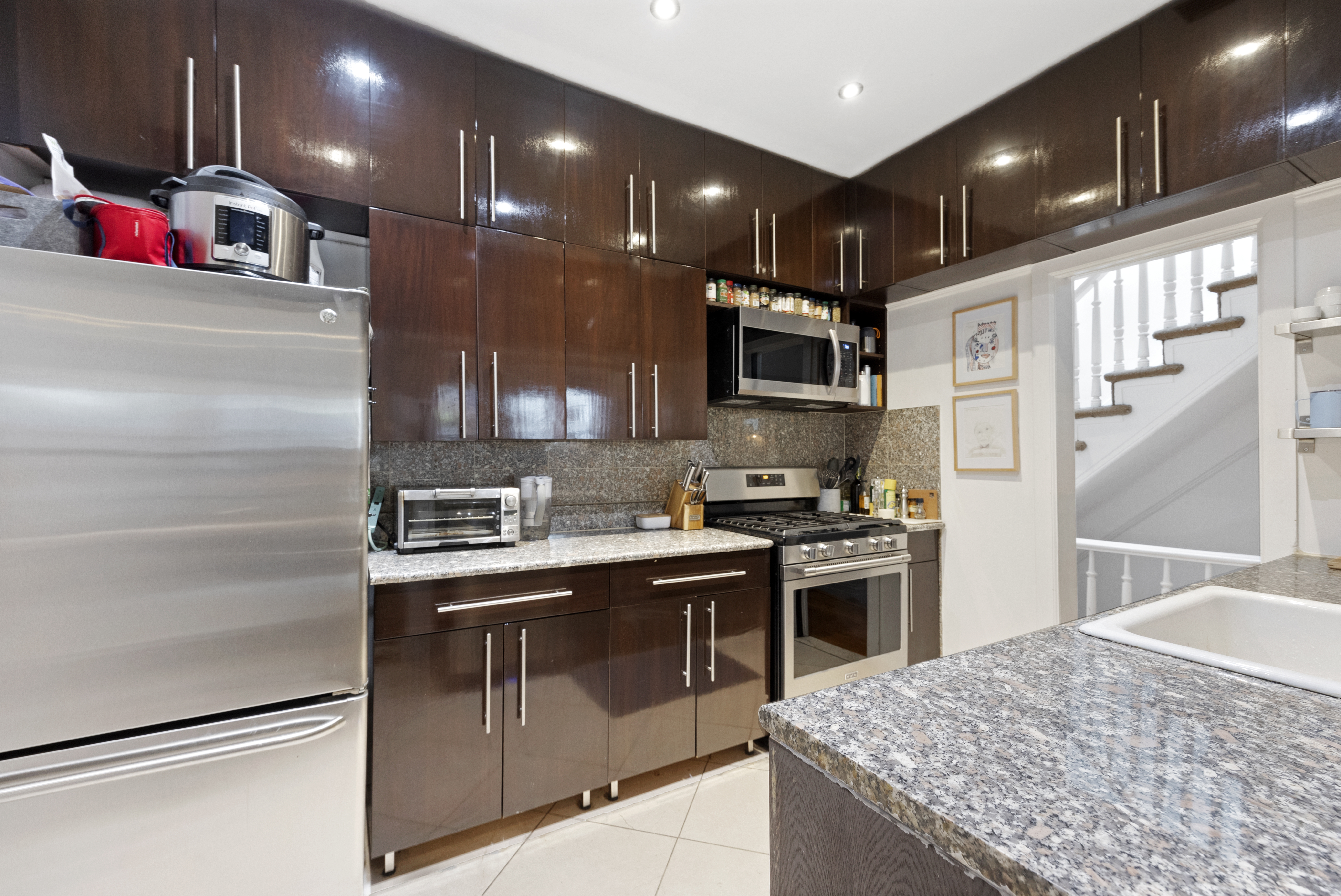 152 East 74th Street, Unit 2 Manhattan, NY 10021 - Photo 6 of 16 a kitchen with kitchen island a sink stove and refrigerator