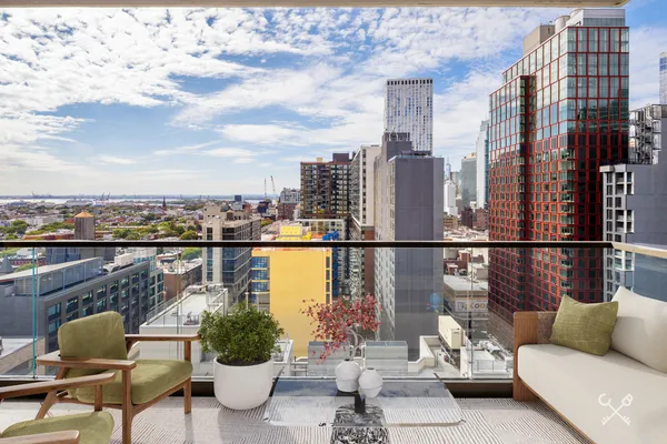a roof deck with couches and potted plants