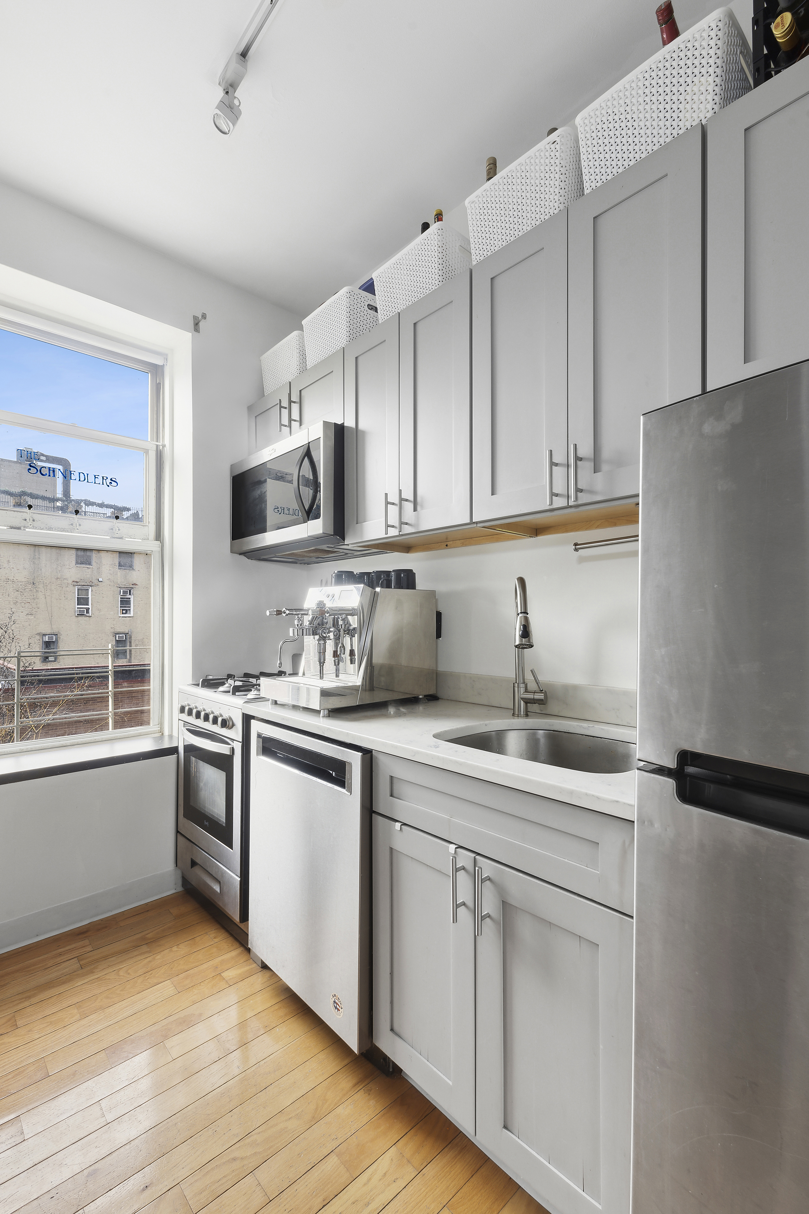 124 Thompson Street, Unit 21 Manhattan, NY 10012 - Photo 3 of 11 a kitchen with stainless steel appliances granite countertop a sink stove and refrigerator