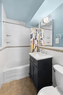 a bathroom with a granite countertop sink mirror vanity and toilet