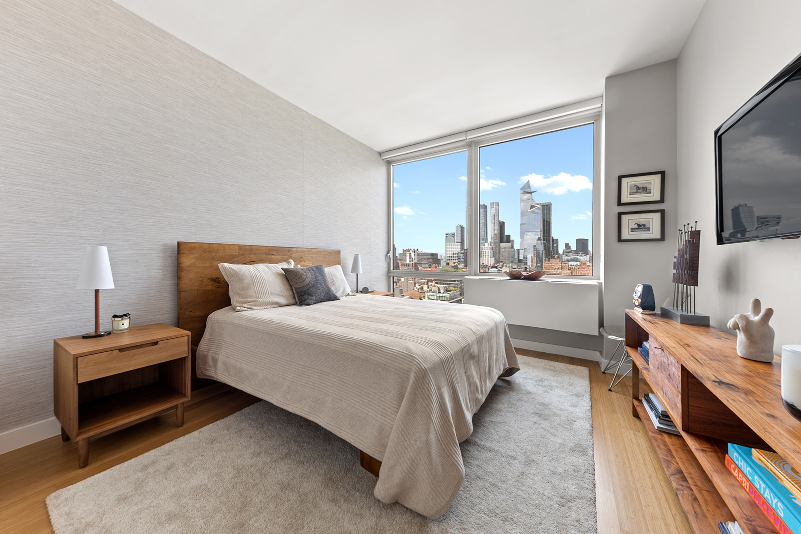 450 West 17th Street, Unit 2208 Manhattan, NY 10011 - Photo 4 of 8 a bedroom with bed and a flat tv screen on dresser