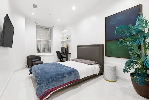 a bedroom with a large bed and a potted plant