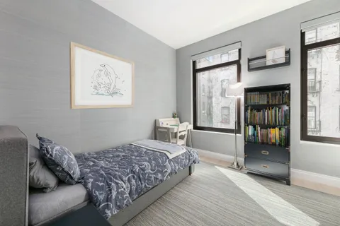 a bedroom with a bed and a large window