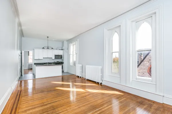 a large kitchen with cabinets and wooden floor