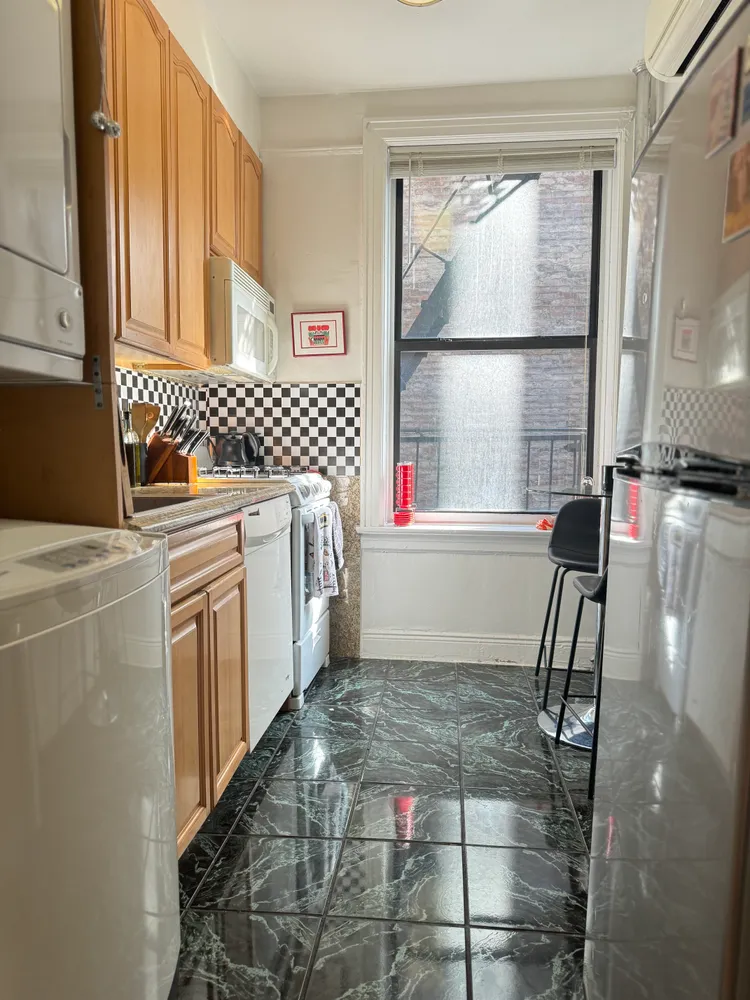 a kitchen with a sink a window and cabinets