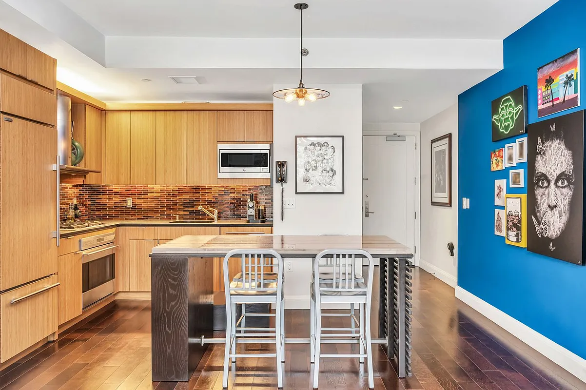 70 Little West Street, Unit 15A Manhattan, NY 10004 - Photo 6 of 19 a kitchen with stainless steel appliances granite countertop a refrigerator a stove a sink dishwasher and white cabinets with wooden floor