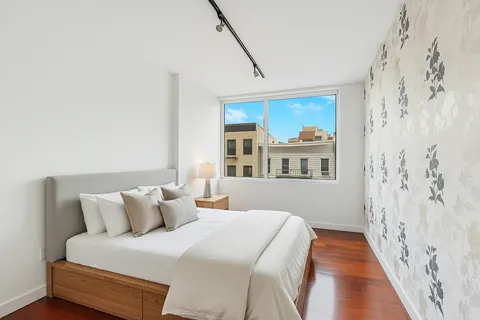 a bed room with a bed and a painting on the wall