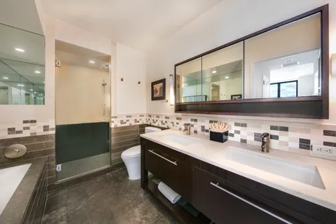 a bathroom with a double vanity sink a mirror and shower