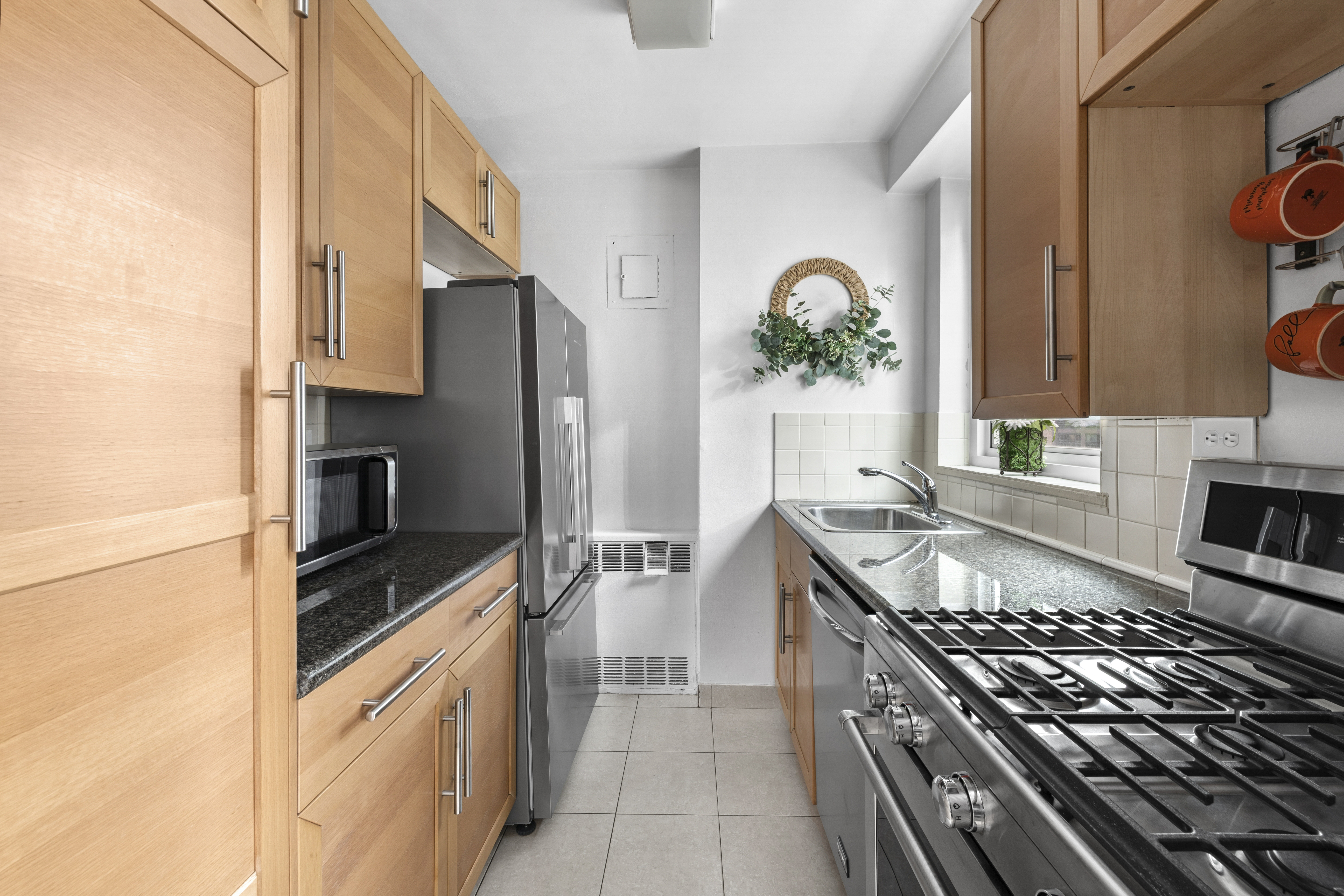 411 East 53rd Street, Unit 16B Manhattan, NY 10022 - Photo 4 of 9 a kitchen with granite countertop a stove and a refrigerator
