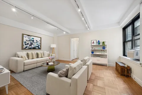 a living room with furniture and a book shelf