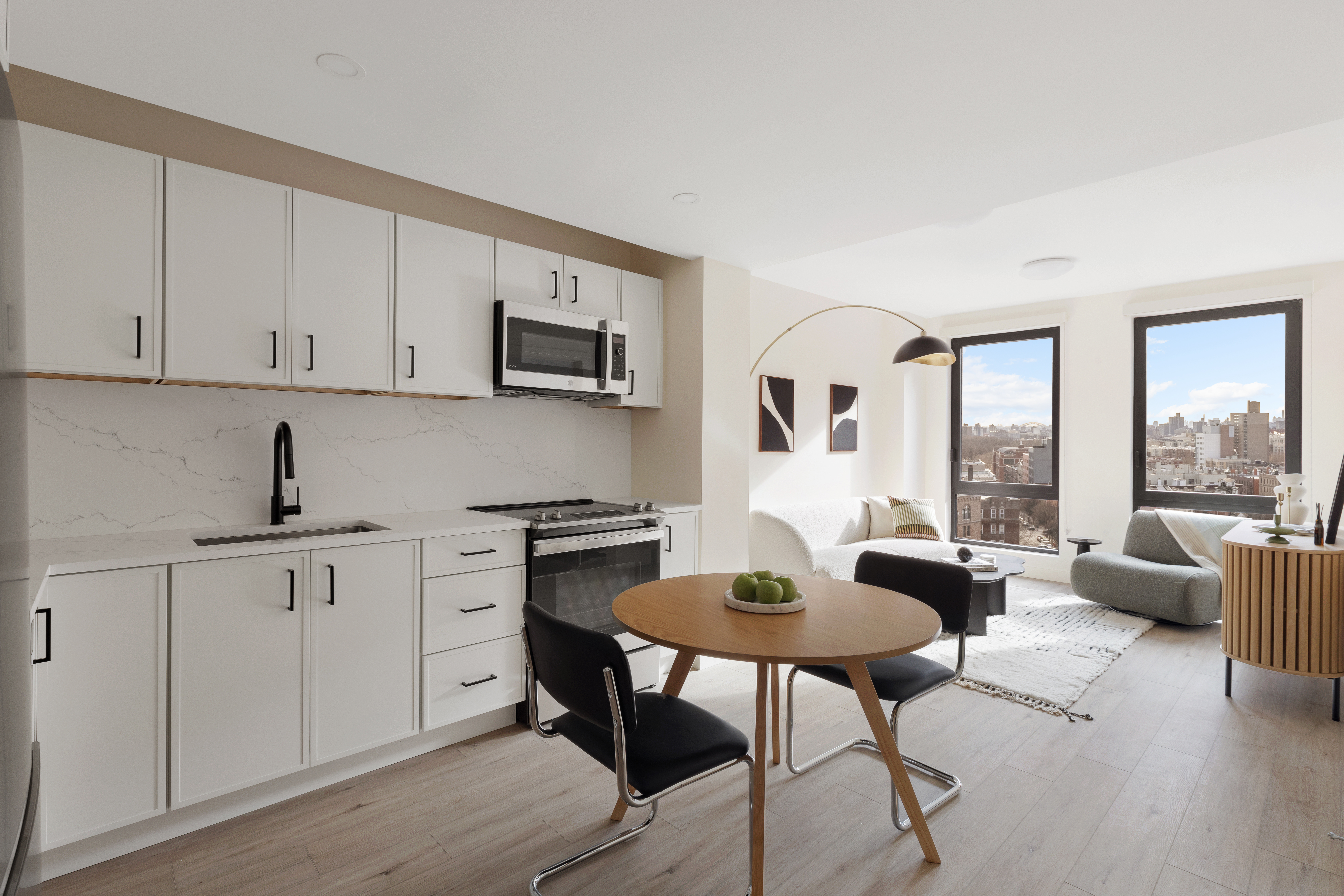 130 East 177th Street, Unit 11F Bronx, NY 10453 - Photo 2 of 18 a kitchen with stainless steel appliances granite countertop a stove a sink dishwasher and white cabinets with wooden floor