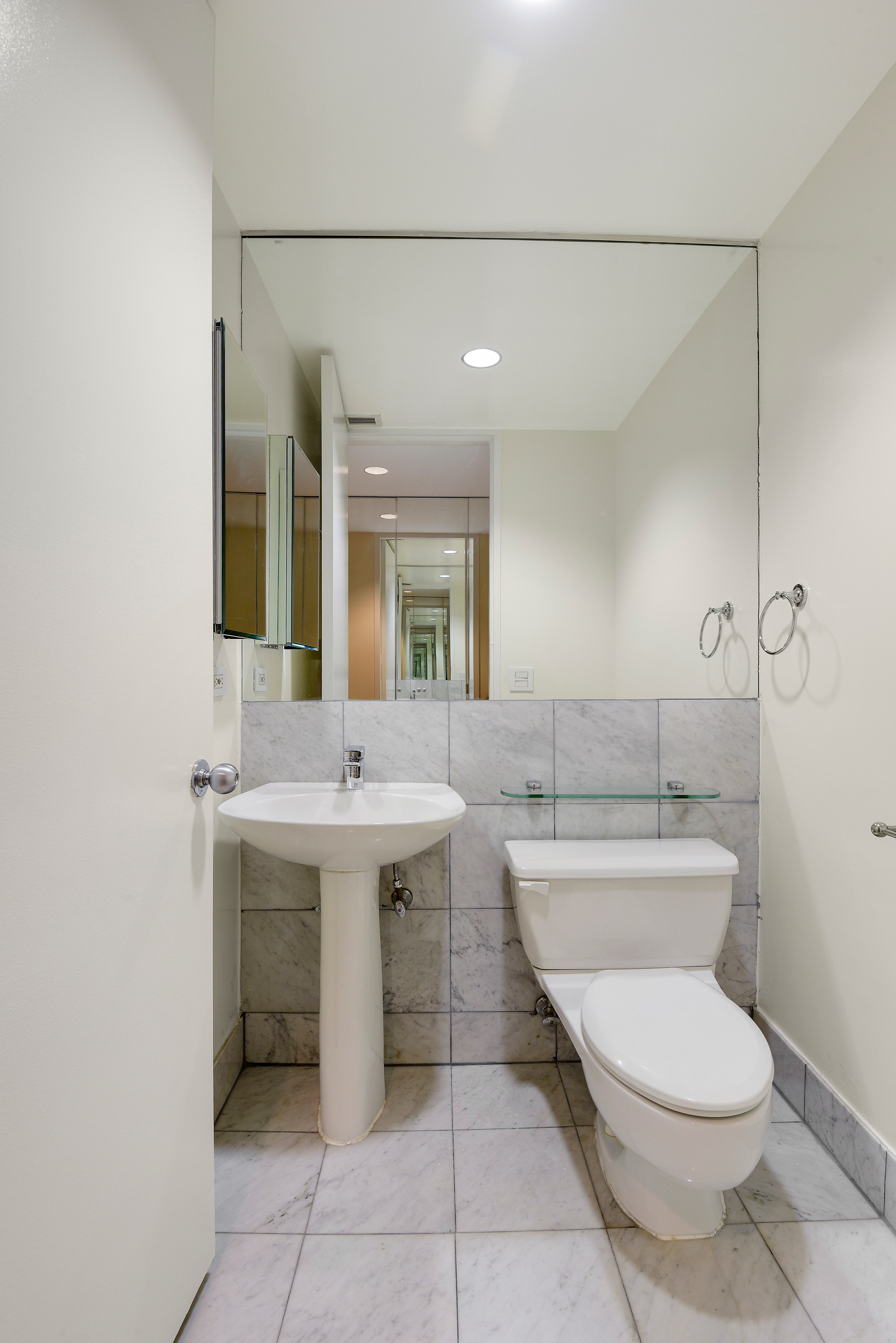 146 West 57th Street, Unit 38E Manhattan, NY 10019 - Photo 8 of 16 a bathroom with a toilet sink and mirror