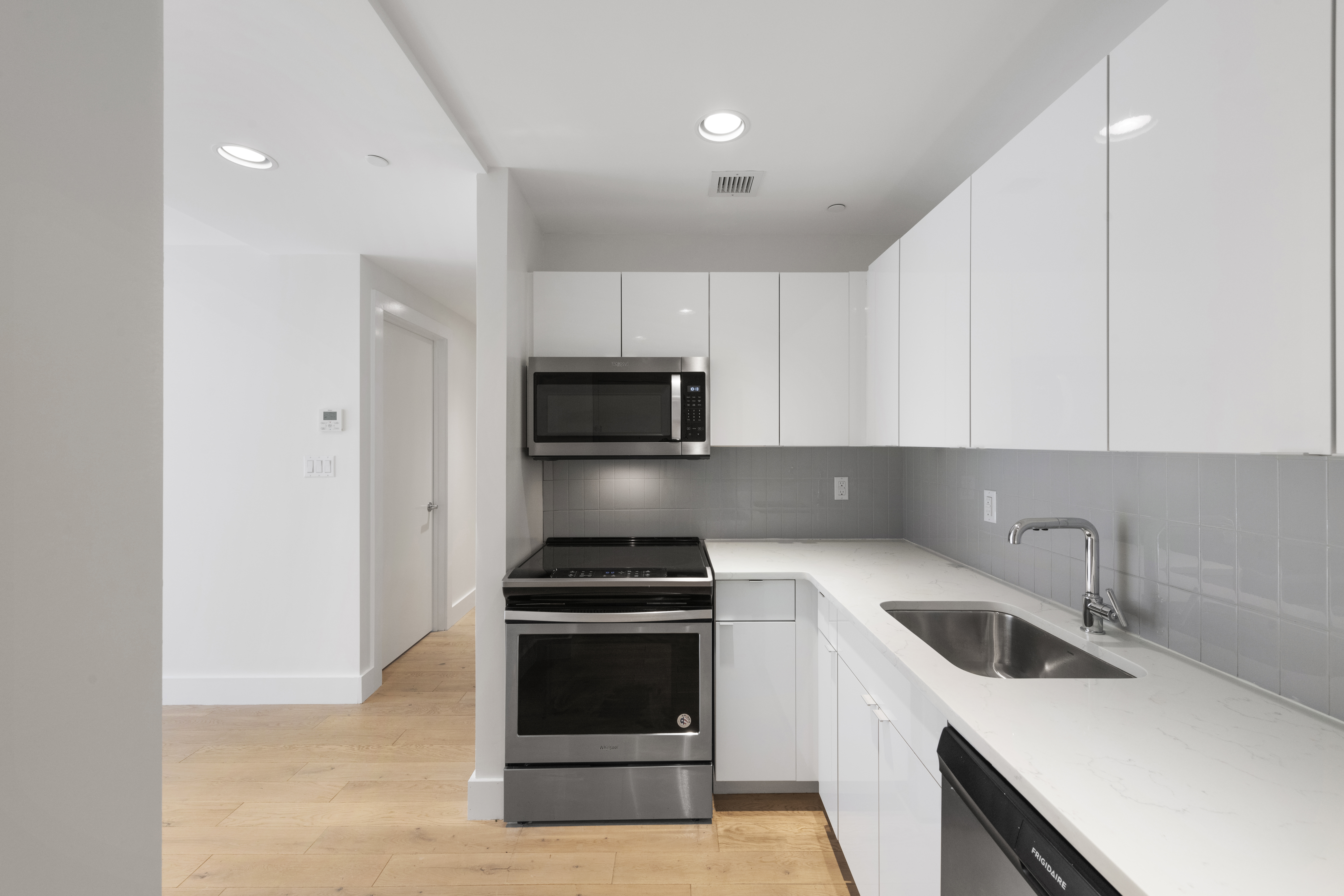 1164 Greene Avenue, Unit 2B Brooklyn, NY 11221 - Photo 3 of 11 a kitchen with white cabinets and stainless steel appliances