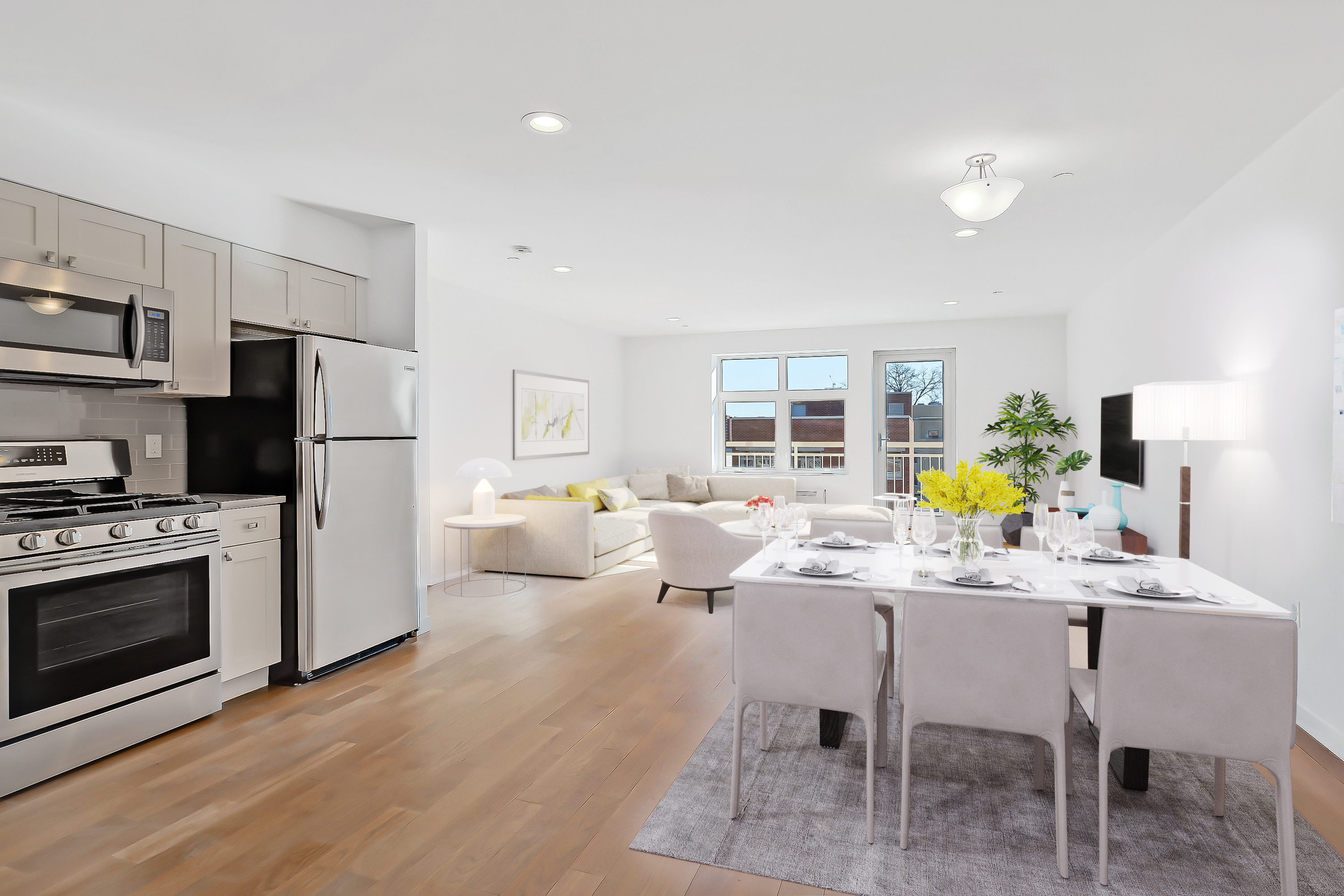26-20 14th Place, Unit 3C Queens, NY 11102 - Photo 2 of 13 a kitchen with stainless steel appliances kitchen island granite countertop a refrigerator a stove a dining table and chairs