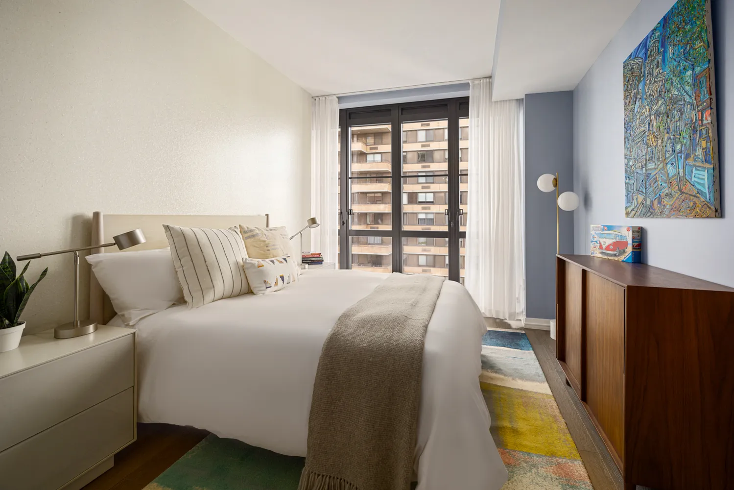 a bedroom with a bed and a large window