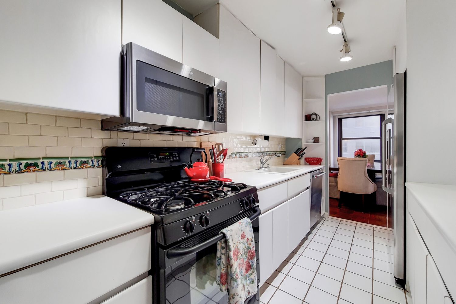 225 East 57th Street, Unit 5K Manhattan, NY 10022 - Photo 7 of 11 a kitchen with a stove and a microwave