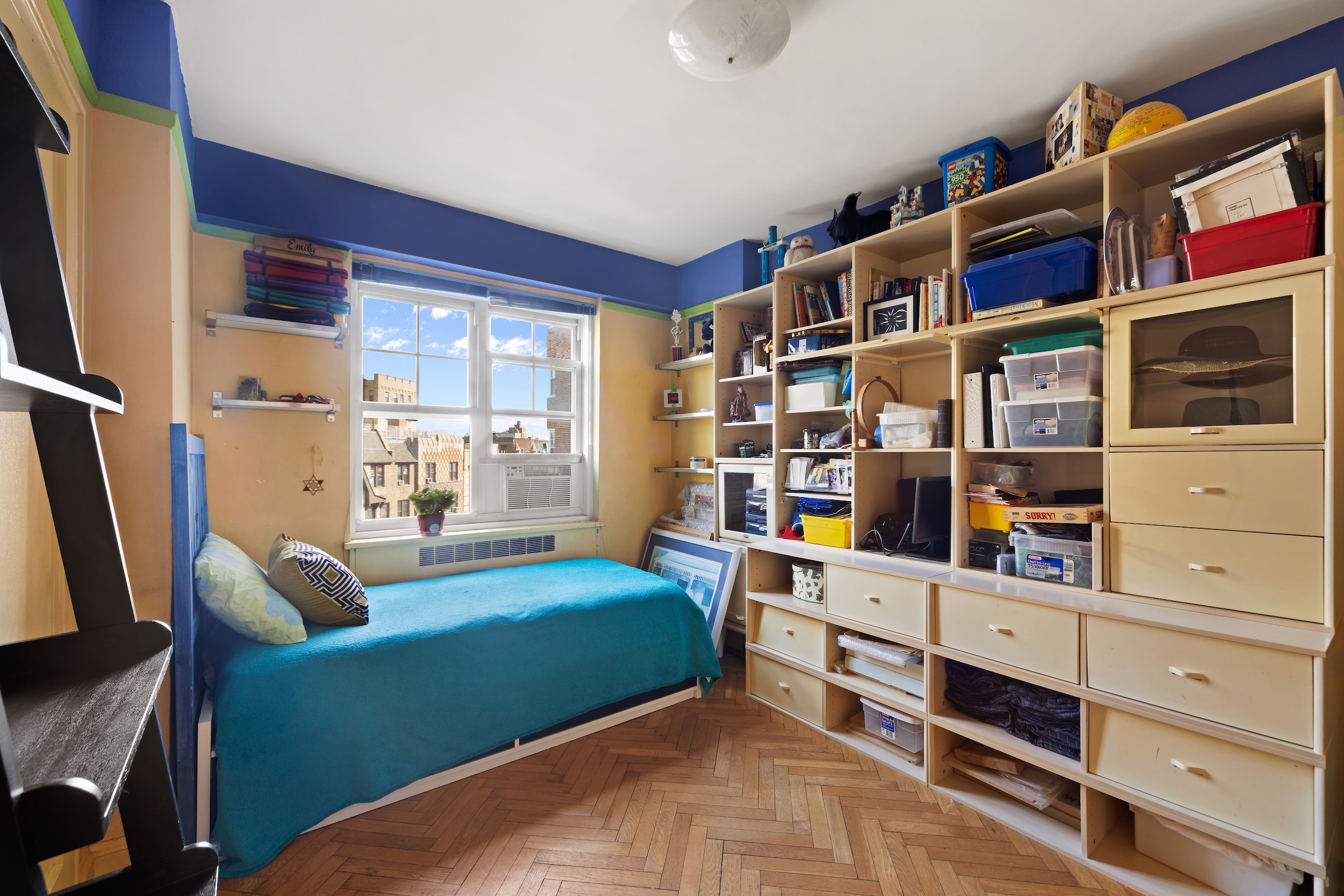 120 Cabrini Boulevard, Unit 76 Manhattan, NY 10033 - Photo 8 of 24 a bedroom with furniture and a book shelf