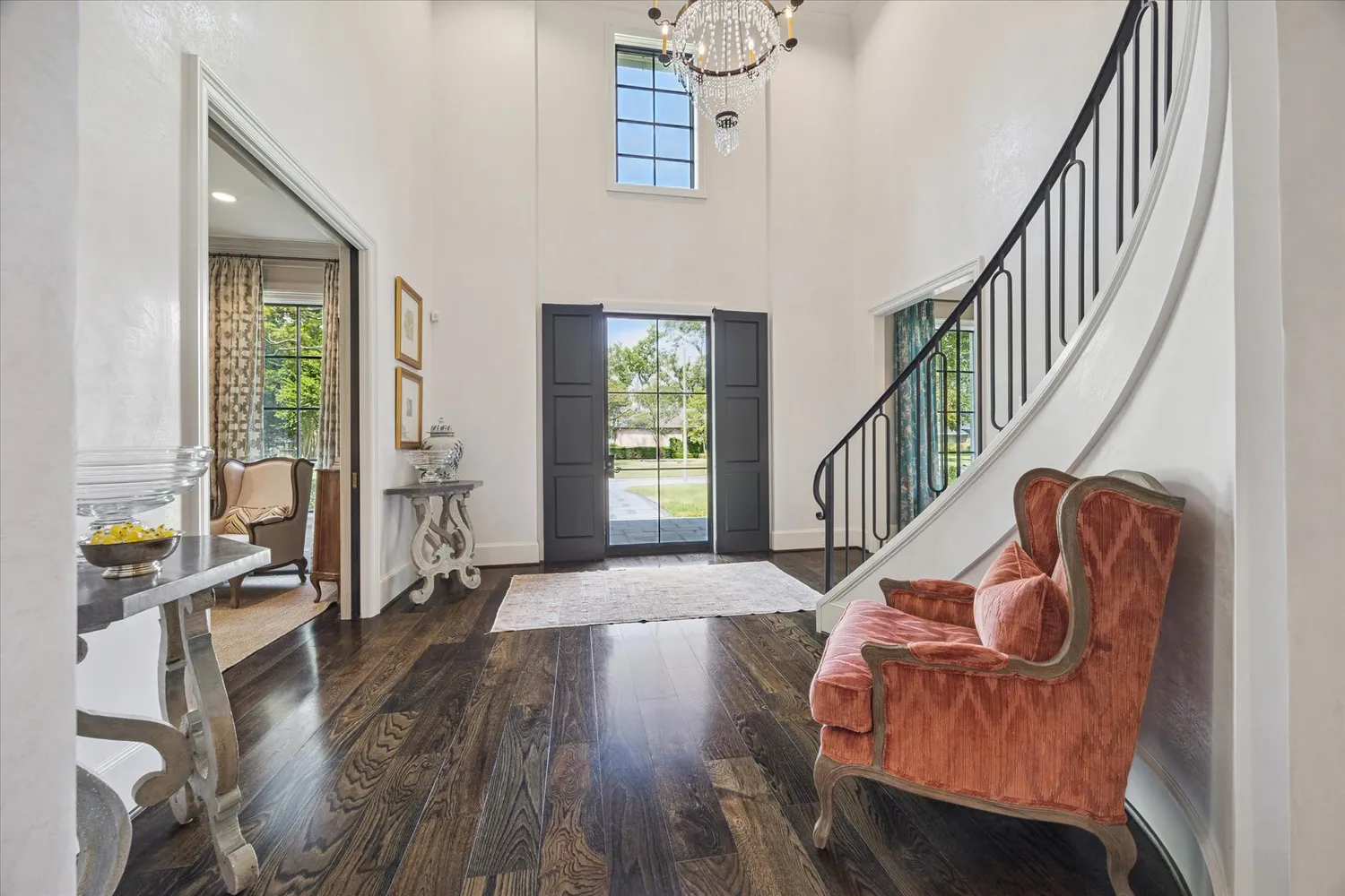 a living room with furniture stairs and a wooden floor