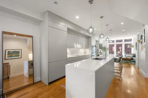 a large kitchen with stainless steel appliances kitchen island a large counter top a sink a stove and a refrigerator