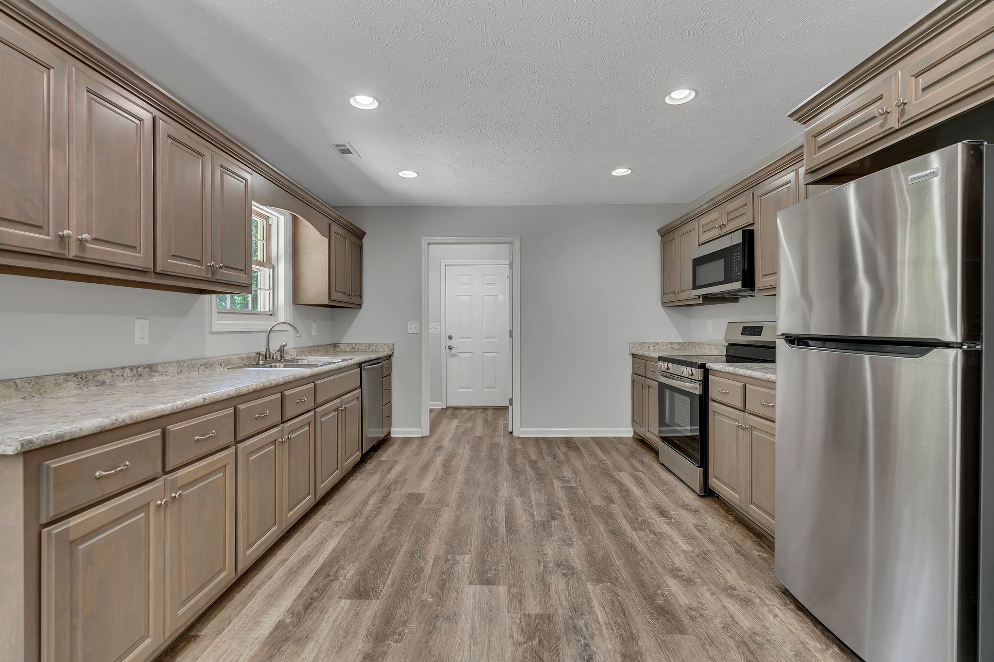 517 Paynes Church Road Estill Springs, TN 37330 - Photo 12 of 32 a kitchen with granite countertop a refrigerator sink and cabinets