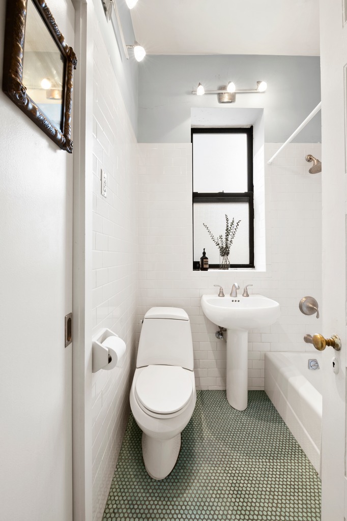 444 East 58th Street, Unit 6C Manhattan, NY 10022 - Photo 6 of 9 a white toilet sitting next to a bathroom sink