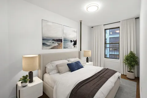 a bedroom with a bed and a potted plant