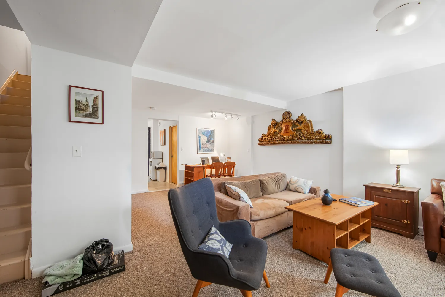 a living room with furniture a rug and a wall painting