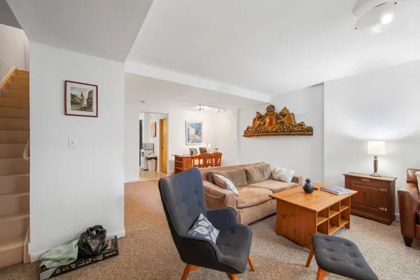a living room with furniture a rug and a wall painting