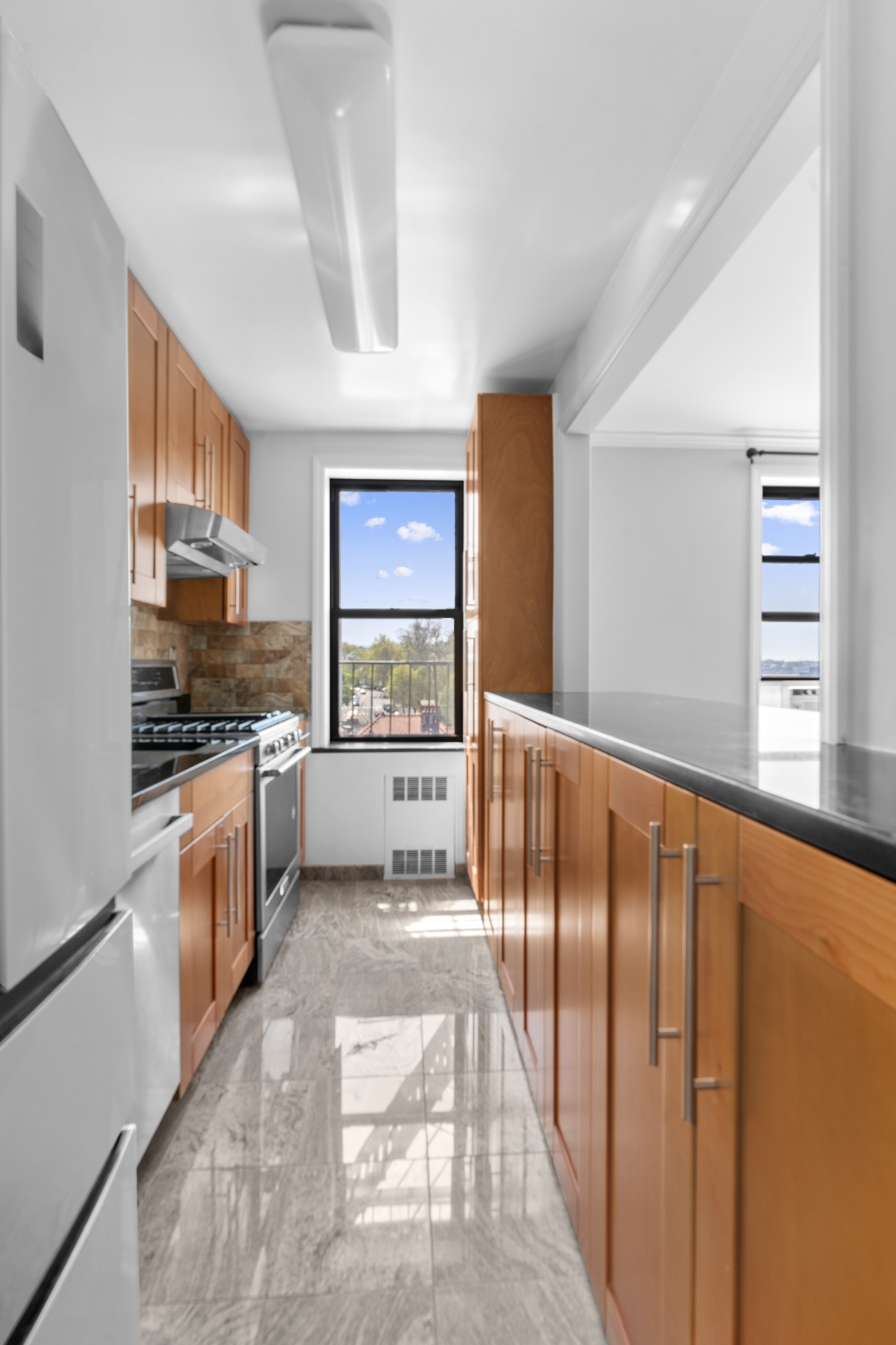 20 89th Street, Unit 5C Brooklyn, NY 11209 - Photo 4 of 10 a kitchen with stainless steel appliances kitchen island granite countertop a refrigerator and a stove top oven