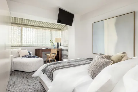 a bedroom with two beds and a large window