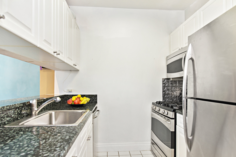 400 East 90th Street, Unit 7E Manhattan, NY 10128 - Photo 3 of 12 a kitchen with a sink and refrigerator