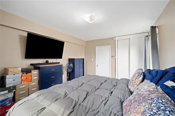 a bedroom with a bed and a flat screen tv