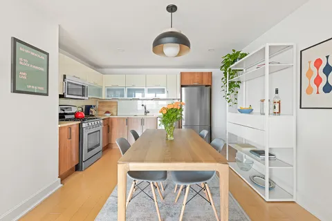 a kitchen with stainless steel appliances kitchen island granite countertop a table and chairs in it