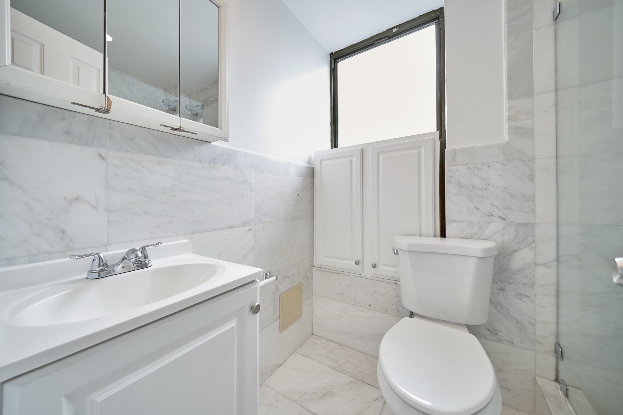 941 Columbus Avenue, Unit 1A Manhattan, NY 10025 - Photo 11 of 14 a white toilet sitting next to a bathroom sink