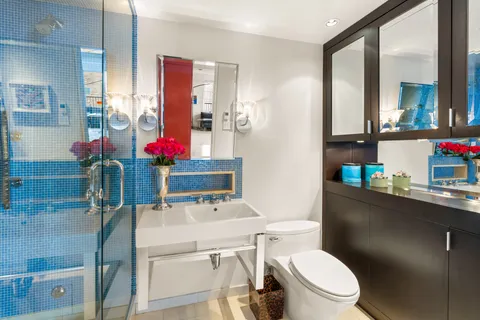 a bathroom with a sink vanity mirror and toilet