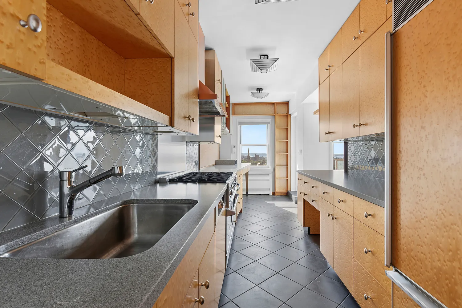 a kitchen with granite countertop a sink and a refrigerator