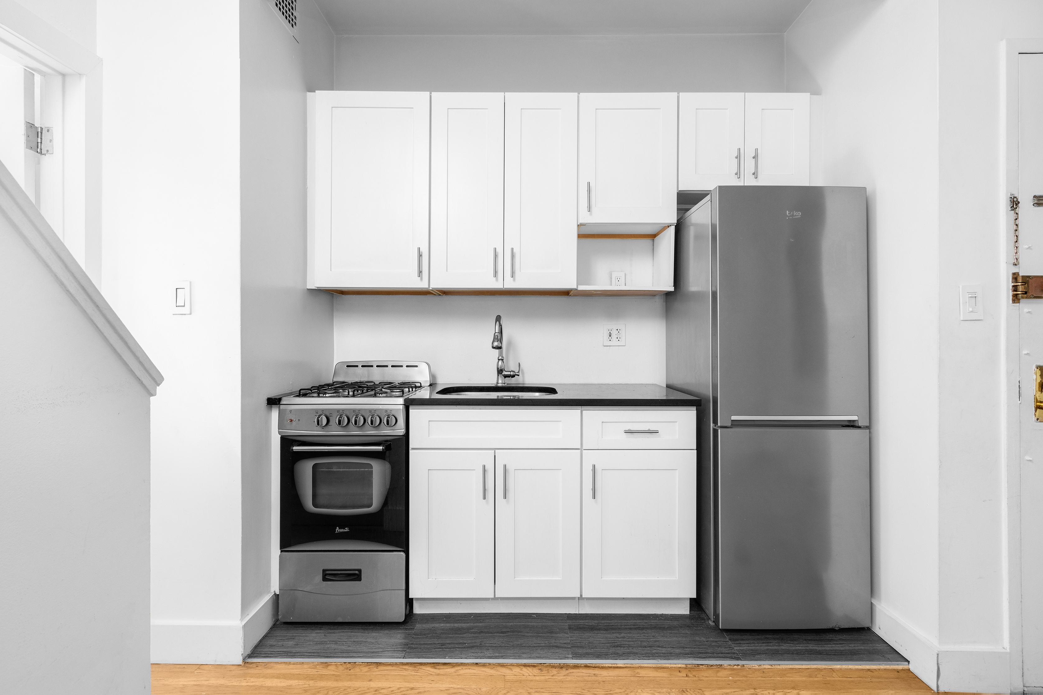 1582 York Avenue, Unit 5B Manhattan, NY 10028 - Photo 5 of 14 a kitchen with stainless steel appliances granite countertop a refrigerator sink and white cabinets