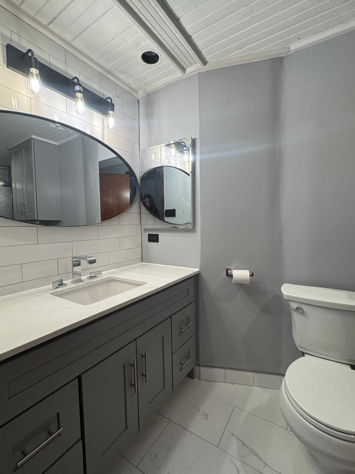 647 East 82nd Street, Unit 2 Brooklyn, NY 11236 - Photo 4 of 6 a bathroom with a toilet sink and mirror