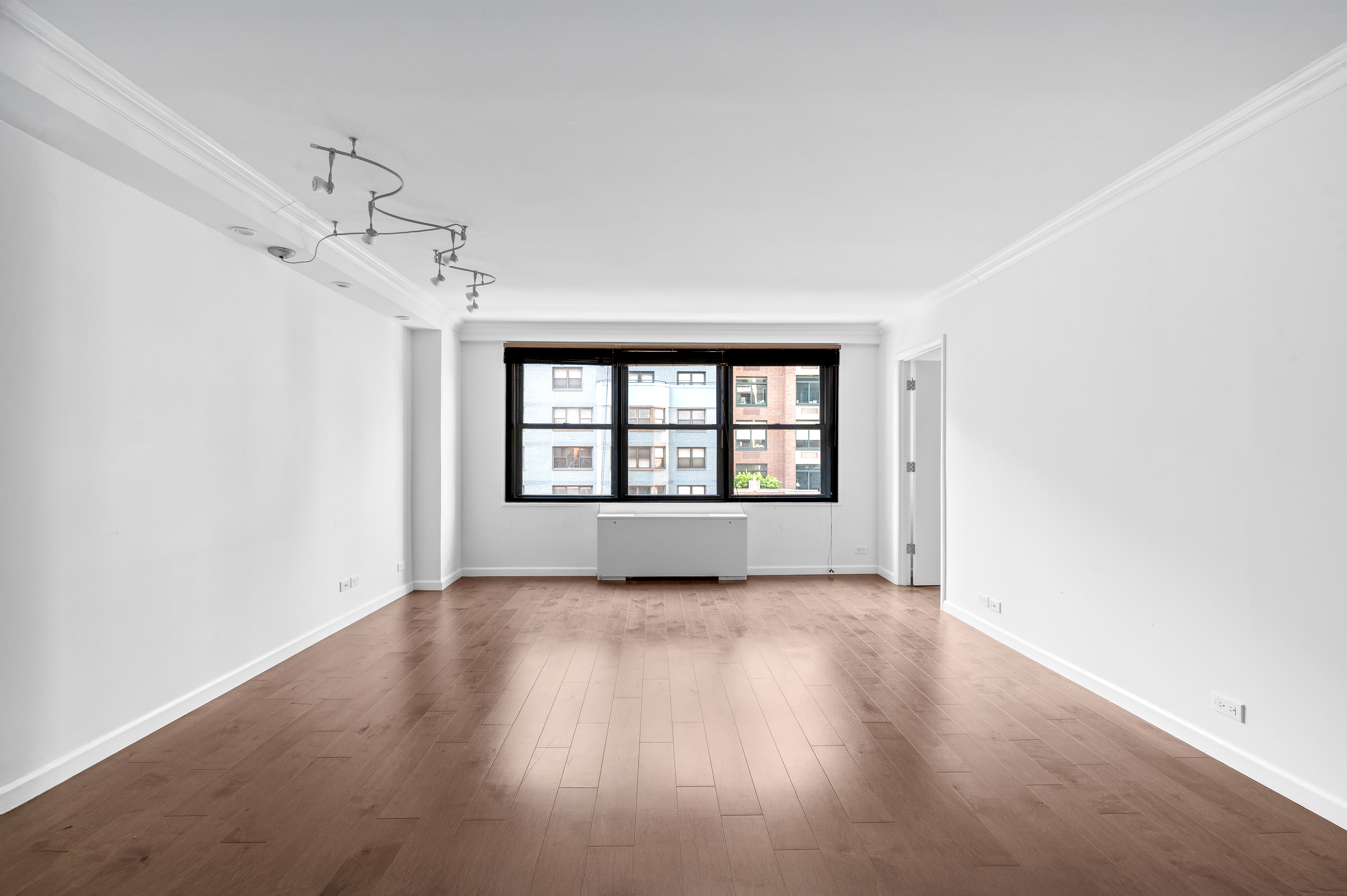 225 East 57th Street, Unit 14F Manhattan, NY 10022 - Photo 2 of 14 a view of an empty room with a window and wooden floor