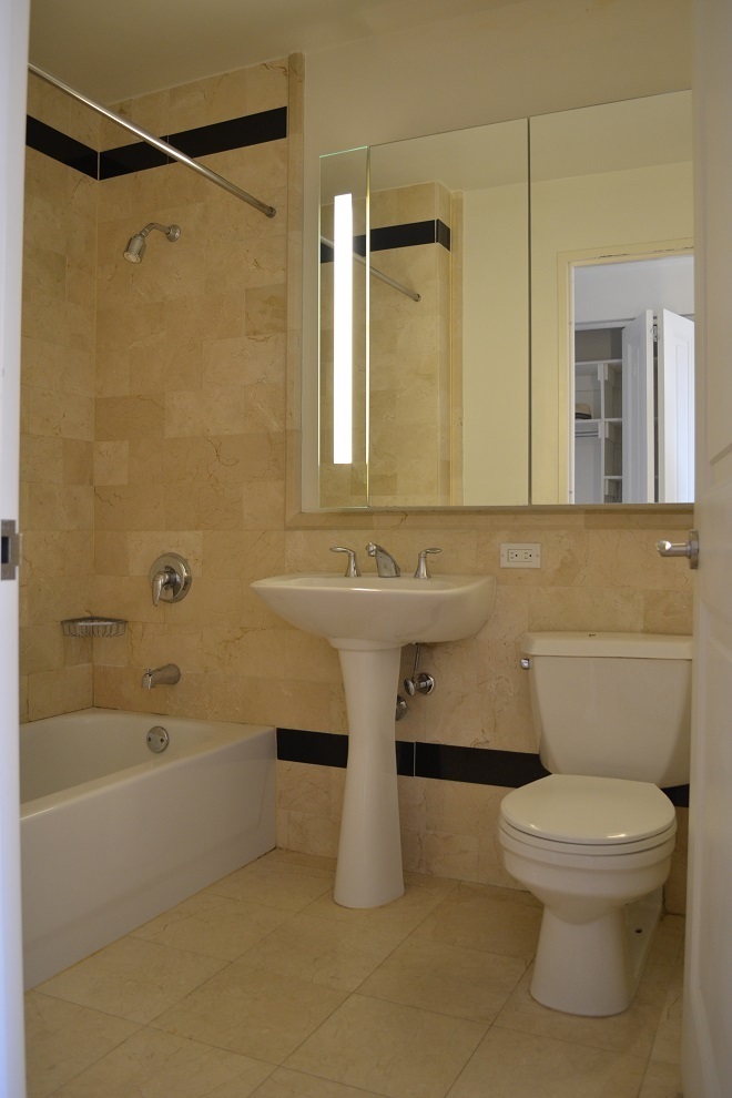 20 West Street, Unit 43E Manhattan, NY 10004 - Photo 5 of 10 a bathroom with a sink a toilet and shower