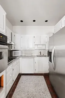 a kitchen with granite countertop white cabinets and white appliances