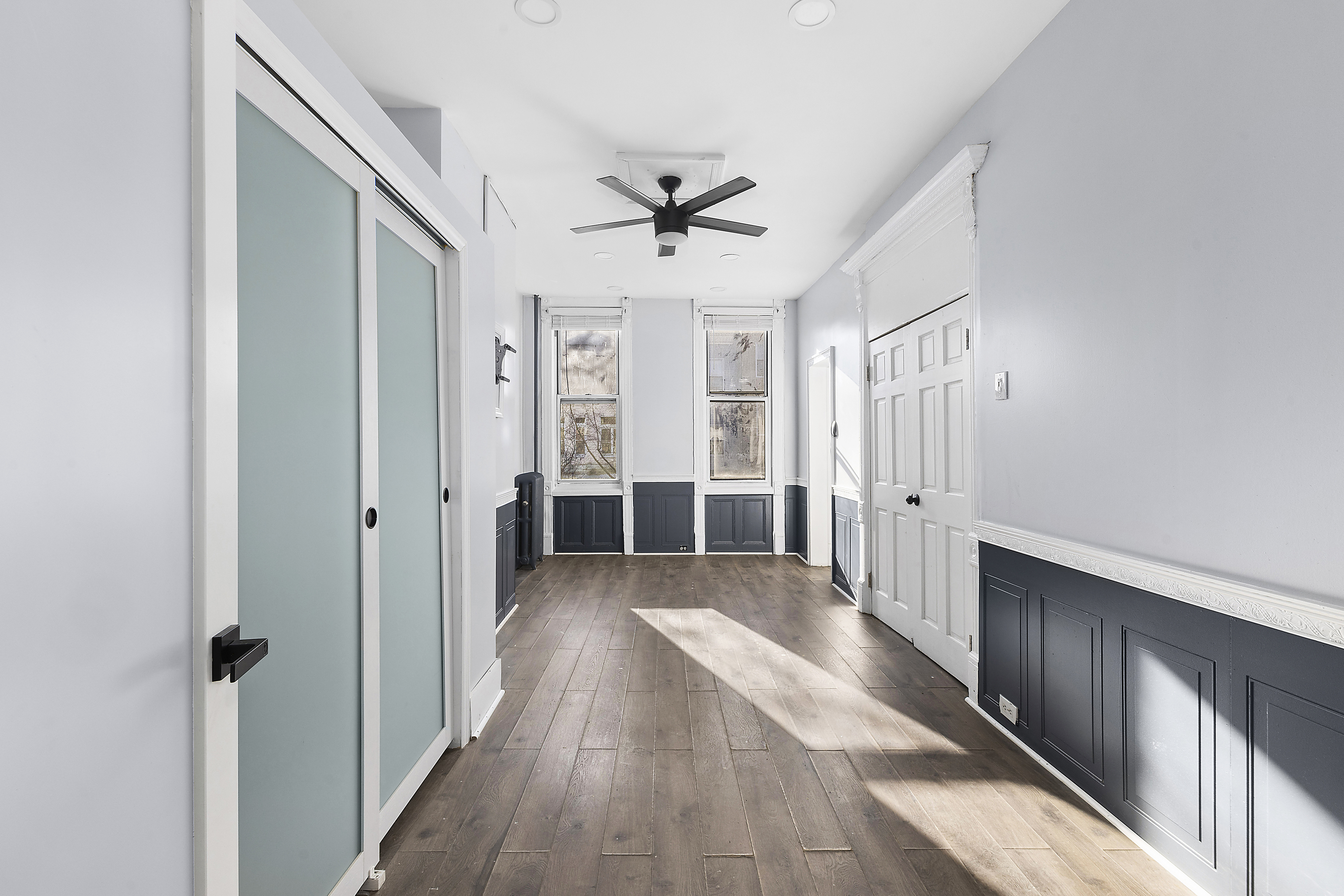 693 MacDonough Street, Unit 2A Brooklyn, NY 11233 - Photo 1 of 11 a view of a hallway with windows and chandelier fan